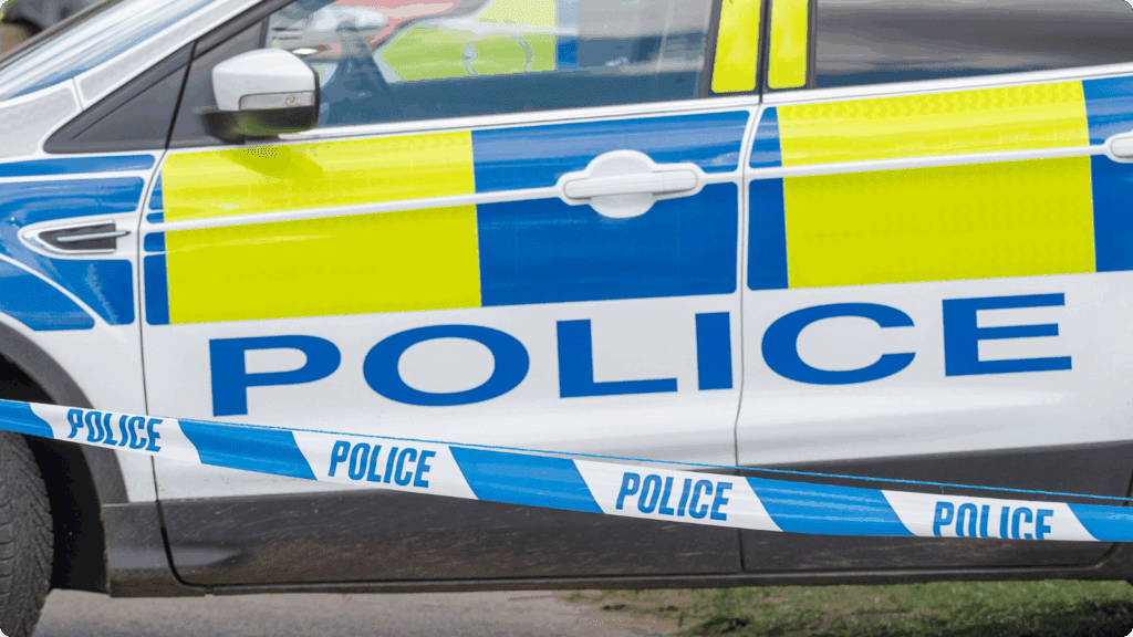 A UK police car with police tape in the foreground